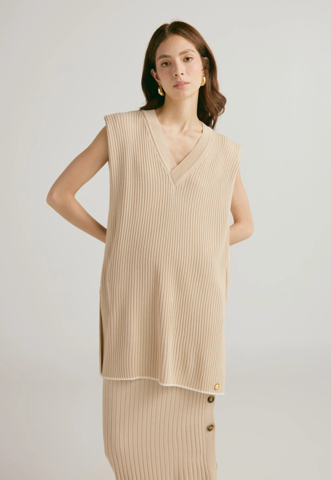 Set de dos prendas Chaleco Andrea, tejido en canal, cuello escote en V, diseño suelto y sin mangas, para mujer. hace conjunto con la Falda Caroline larga de tejido acanalado, talle alto, con botones laterales, en material de hilo para mujer.