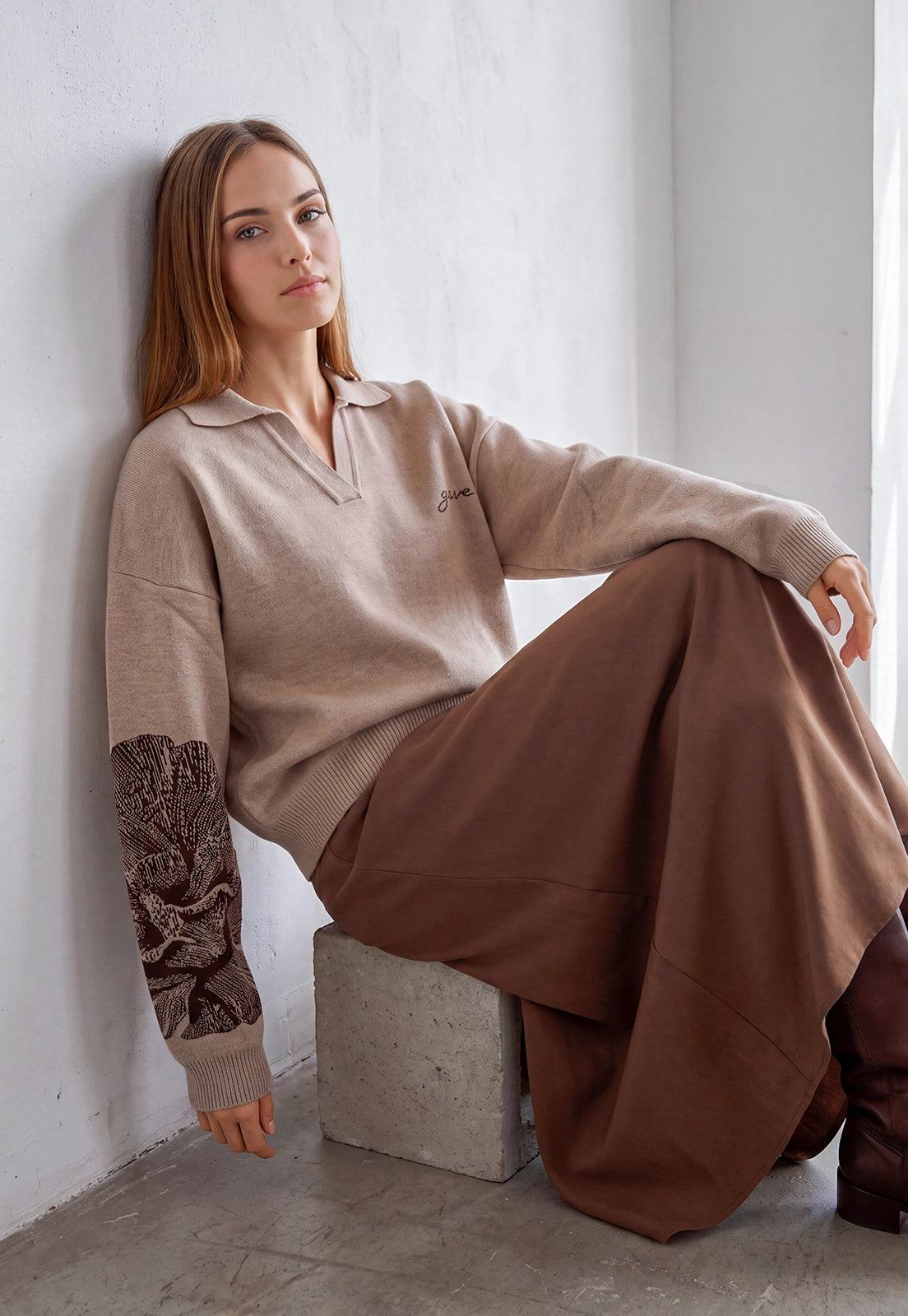 Buzo Adele Giive beige tejido con cuello tipo polo, manga larga y flor de gran formato en la espalda.