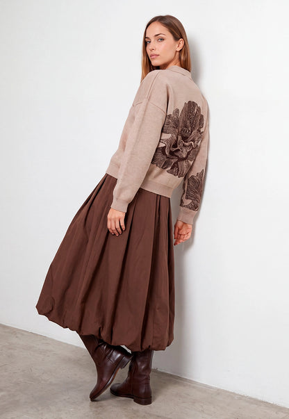 Buzo Adele Giive beige tejido con cuello tipo polo, manga larga y flor de gran formato en la espalda.