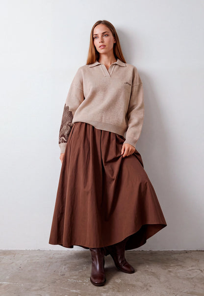 Buzo Adele Giive beige tejido con cuello tipo polo, manga larga y flor de gran formato en la espalda.