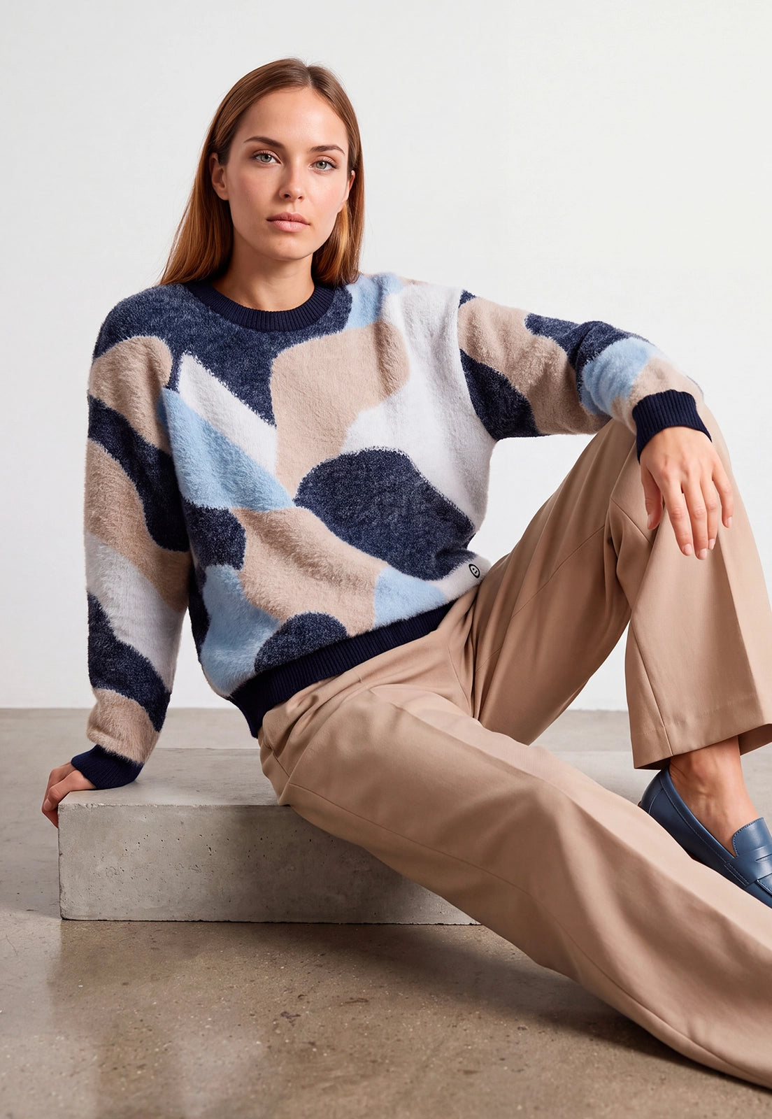 Buzo Amelia Giive tejido de textura afelpada con diseño geométrico abstracto en beige, azul oscuro, azul claro y blanco.