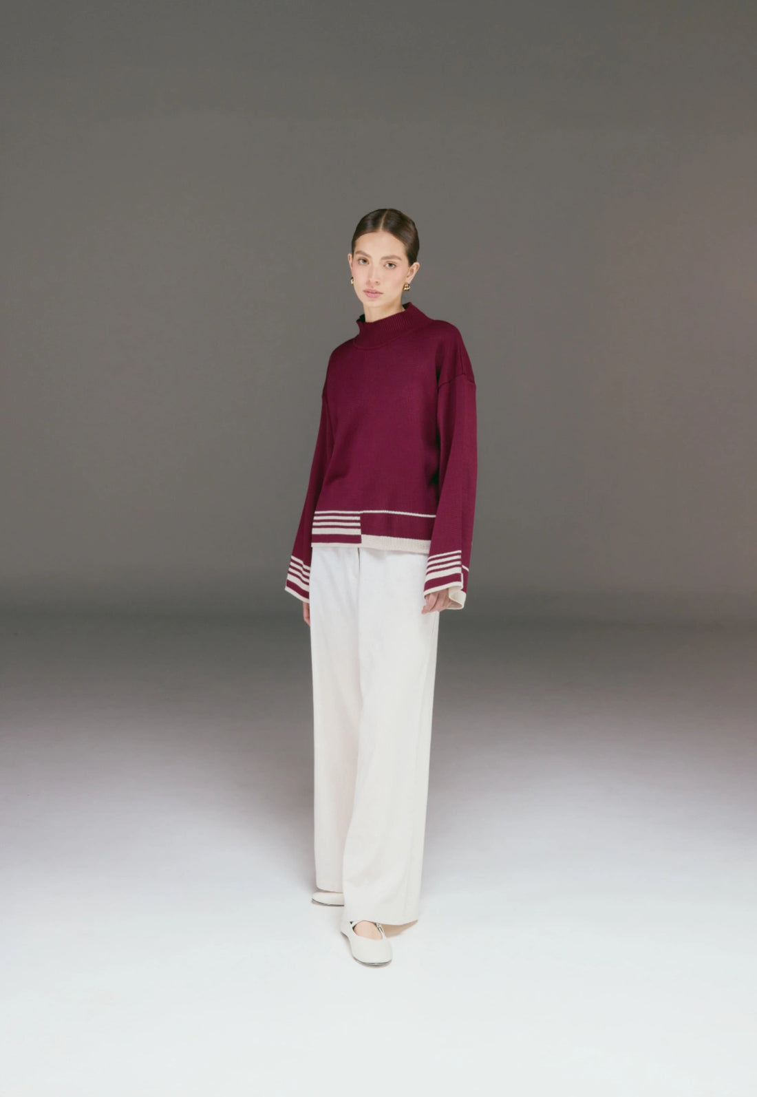 Buzo Amanda de cuello alto para mujer, con corte holgado y tejido Jacquard, detalle lineal en puños y parte inferior.