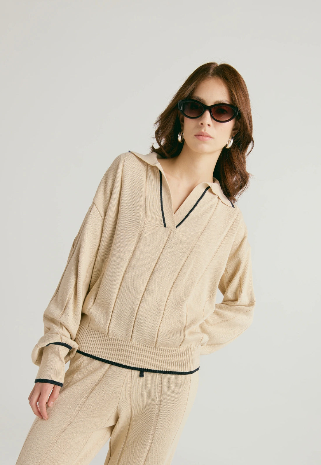 Suéter de tejido suave con cuello en V, manga caída y corte suelto para mujer.