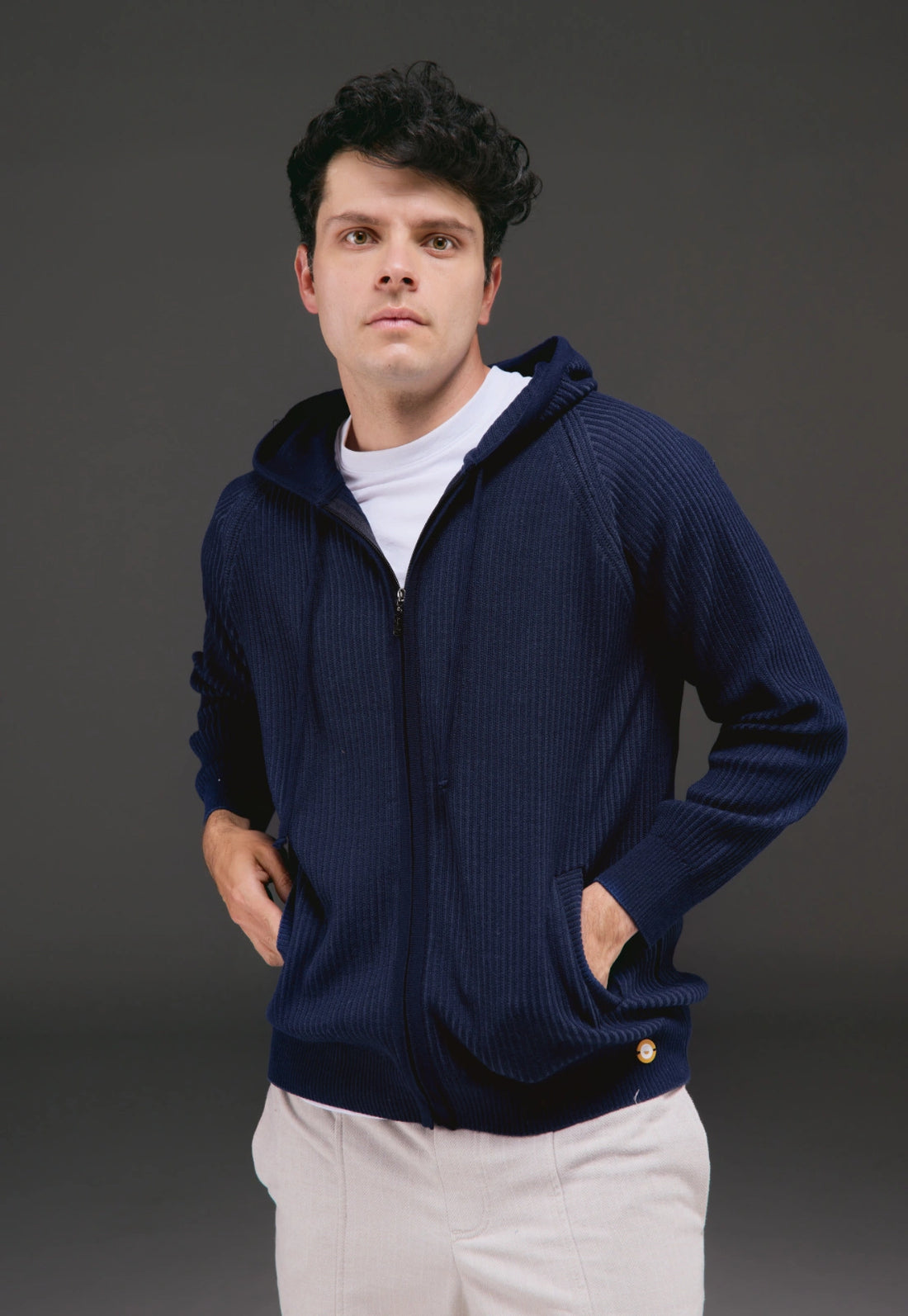 Hoodie tejido para hombre con cremallera doble sentido, capucha ajustable y bolsillos laterales visibles.