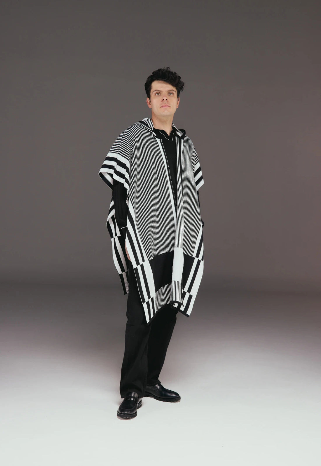 Ruana Taylor unisex en tejido jacquard con capota, diseño de líneas verticales, dos colores, estilo moderno.
