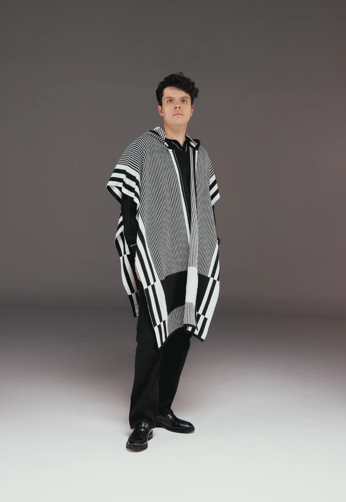 Ruana Taylor unisex en tejido jacquard con capota, diseño de líneas verticales, dos colores, estilo moderno.
