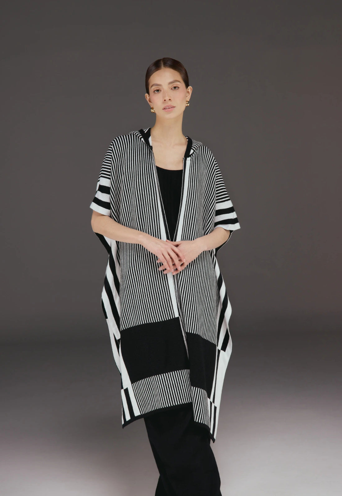 Ruana Taylor unisex en tejido jacquard con capota, diseño de líneas verticales, dos colores, estilo moderno.
