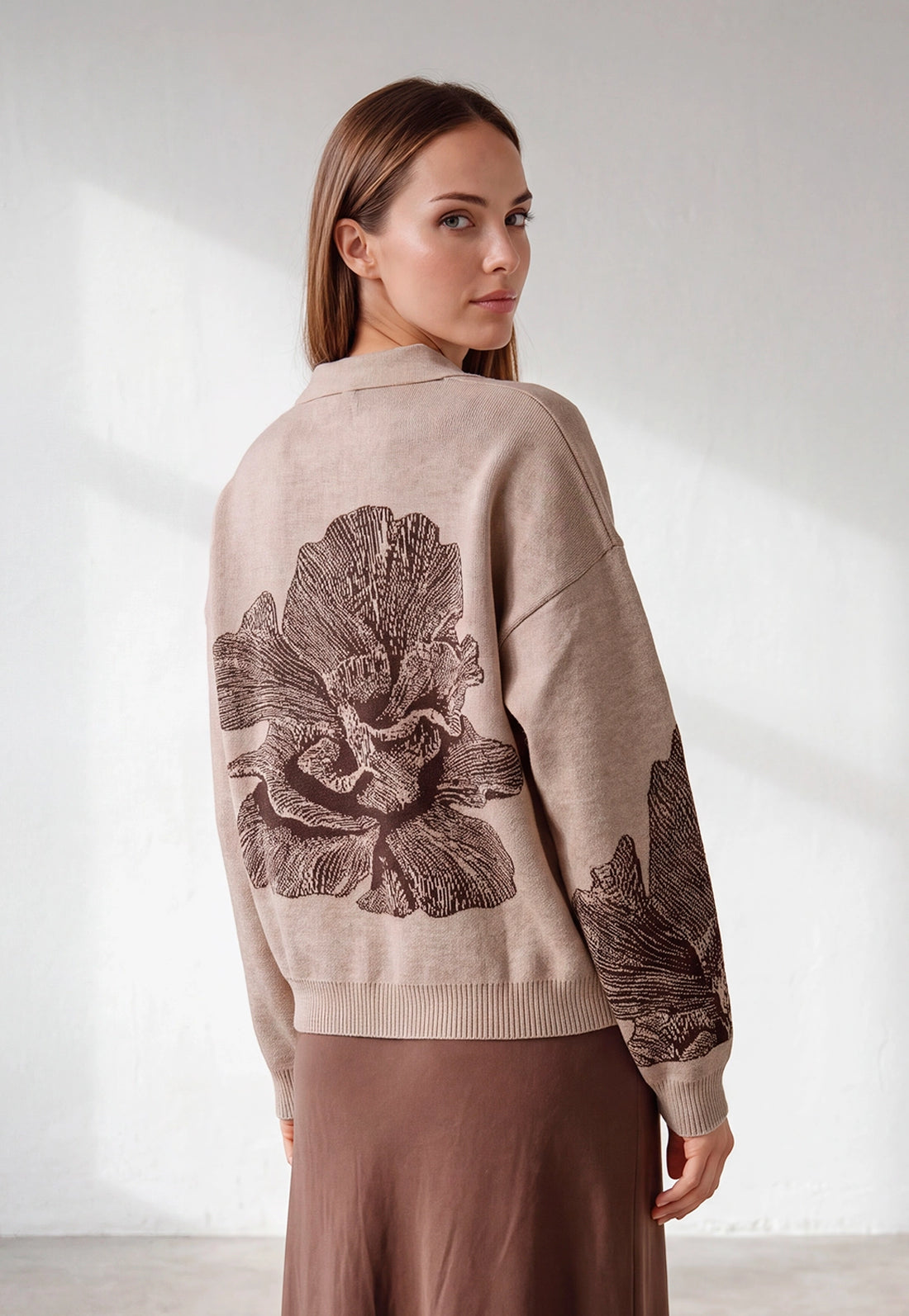 Buzo Adele Giive beige tejido con cuello tipo polo, manga larga y flor de gran formato en la espalda.