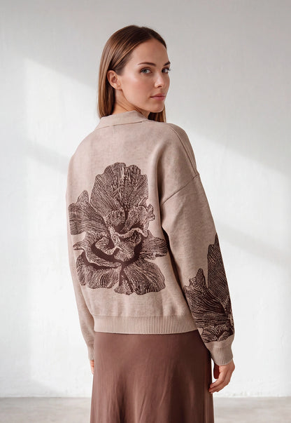 Buzo Adele Giive beige tejido con cuello tipo polo, manga larga y flor de gran formato en la espalda.