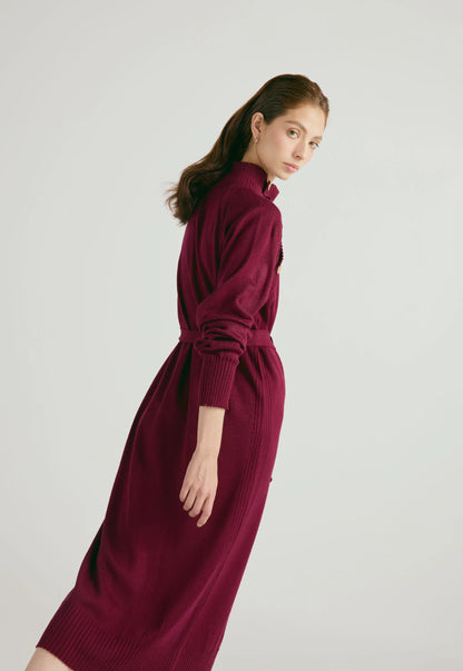 Vestido Danielle largo para mujer con cuello alto, botones dorados, cinturón ajustable y abertura en la falda, en tejido de punto cerrado.
