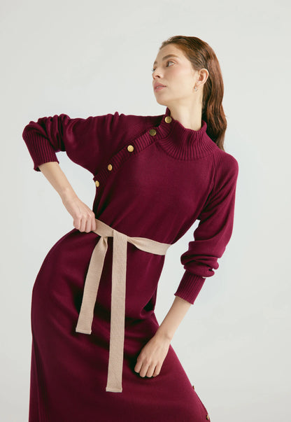 Vestido Danielle largo para mujer con cuello alto, botones dorados, cinturón ajustable y abertura en la falda, en tejido de punto cerrado.
